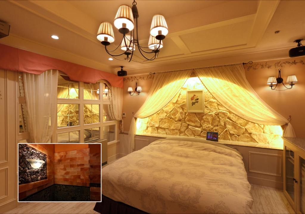 une chambre avec un lit et un mur en pierre dans l'établissement Osyare Kizoku Ichinomiya (Adult Only), à Ichinomiya 2 autres photos