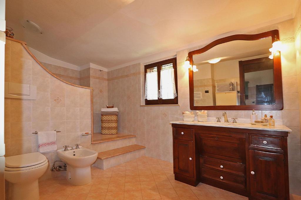 une salle de bain avec un lavabo, des toilettes et un miroir dans l'établissement Villa Durante, à Cagli 44 autres photos