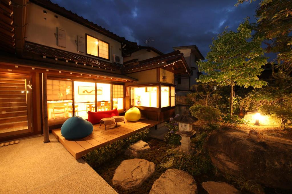 une maison avec une terrasse couverte en bois et un canapé rouge dans l'établissement Ichinomatsu Japanese Modern Hotel, à Takayama 37 autres photos