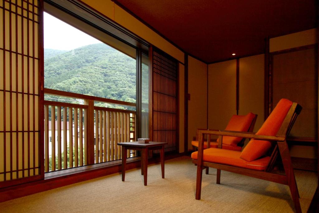 une pièce avec une chaise et une grande fenêtre dans l'établissement Hakone Onsen Ryokan Yaeikan, à Hakone 37 autres photos