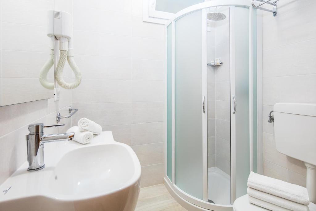 une salle de bain avec une douche, des toilettes et un lavabo dans l'établissement Hotel Meublè Zenith, à Lignano Sabbiadoro