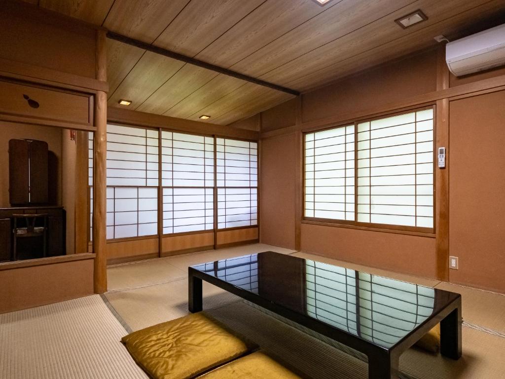 Cette chambre dispose d'une table et de fenêtres. dans l'établissement Hakone Onsen Sanso Nakamura, à Hakone 26 autres photos