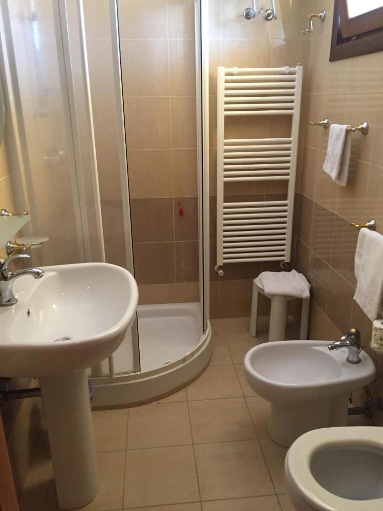 une salle de bain avec douche, lavabo et toilettes dans l'établissement Laghi Room Only, à Sibari