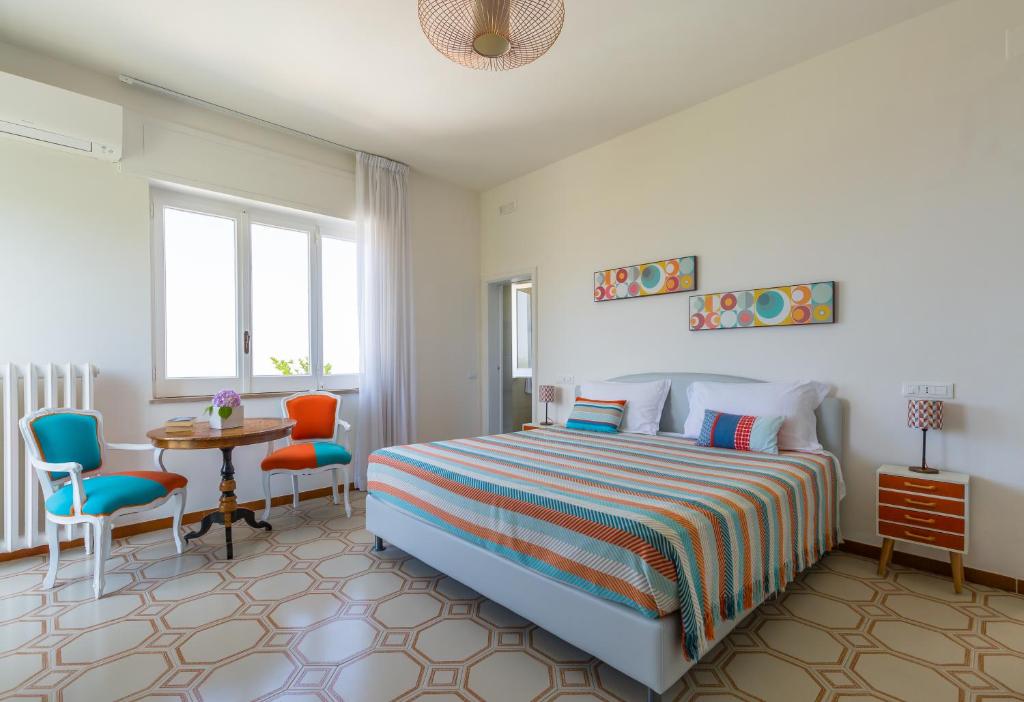 une chambre avec un lit, une table et des chaises dans l'établissement Villa Sorrento Flats, à Sorrente