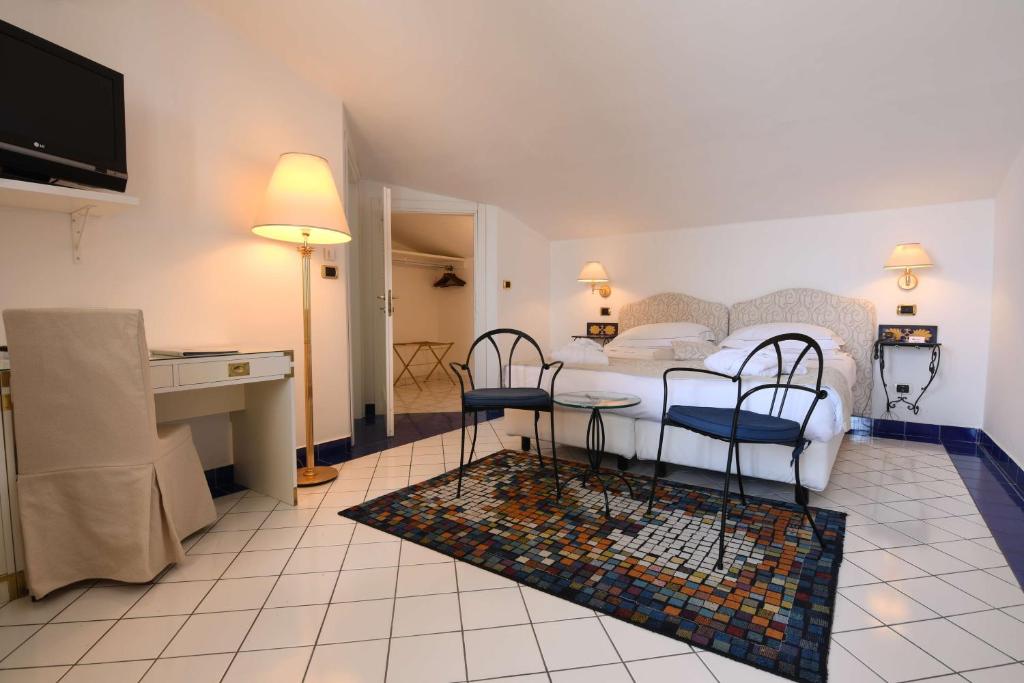 un salon avec un lit, une table et des chaises dans l'établissement Best Western Hotel Acqua Novella, à Spotorno