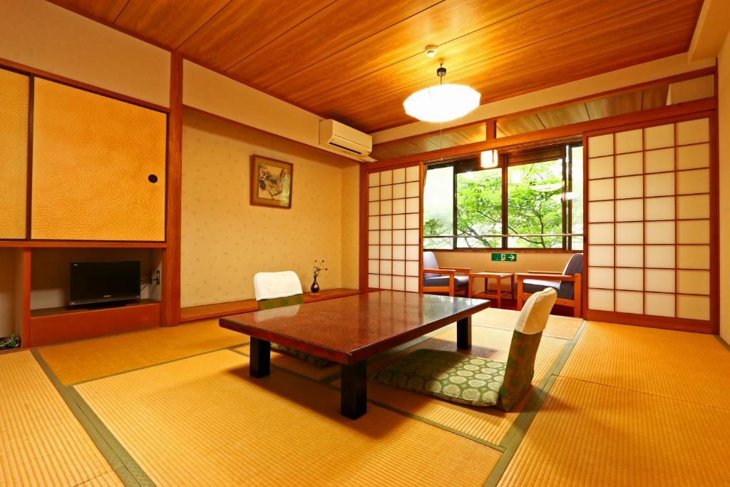 un salon avec une table et des chaises en bois dans l'établissement Hounkan, à Yoshino