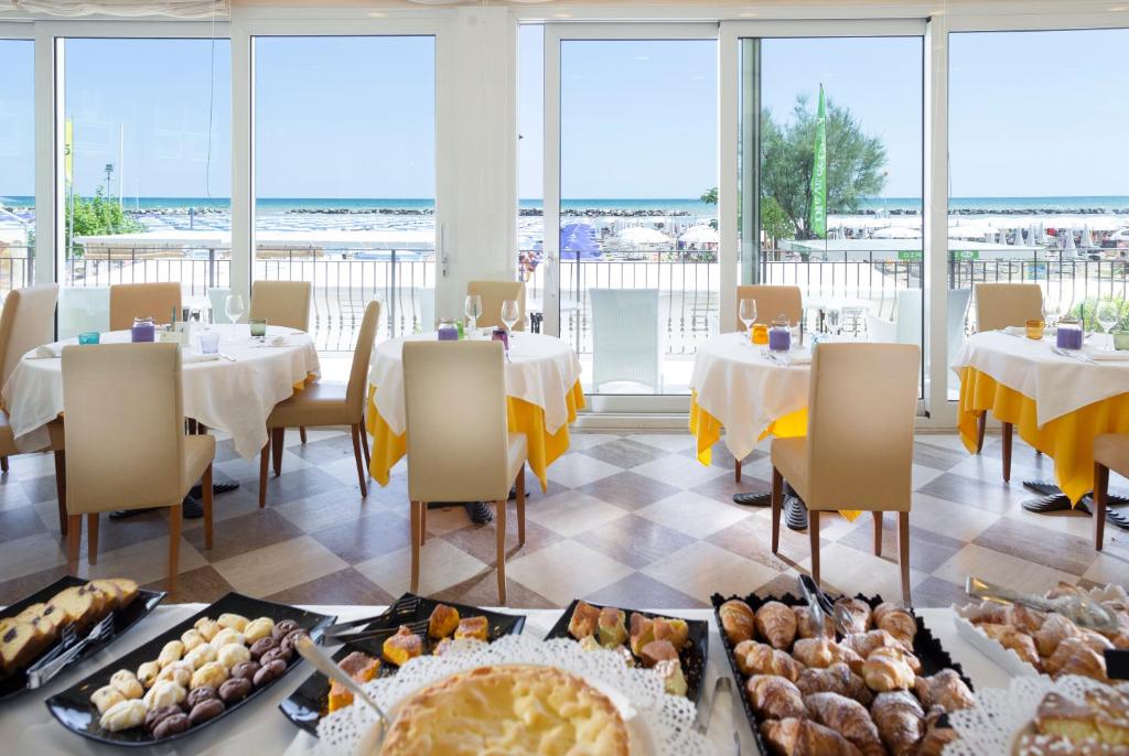 - un restaurant avec des tables et des chaises où vous pourrez manger dans l'établissement Hotel Orizzonte, à Bellaria-Igea Marina