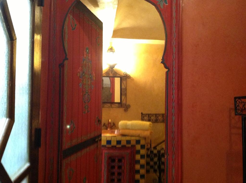 La salle de bains est pourvue d'une porte rouge et d'un miroir. dans l'établissement Ryad Bahia, à Meknès 37 autres photos