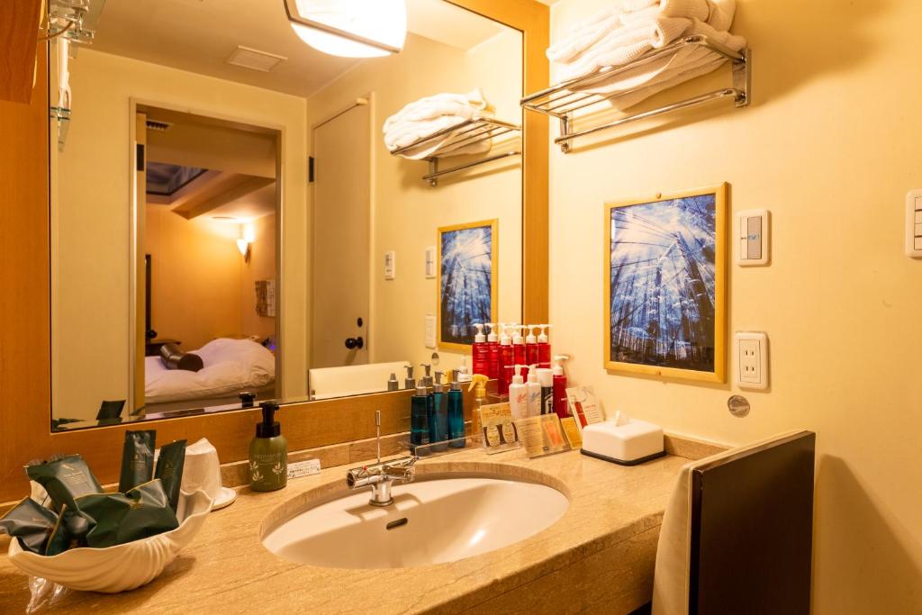 une salle de bain avec un lavabo et un grand miroir dans l'établissement Water Hotel Mw (Love Hotel), à Saitama