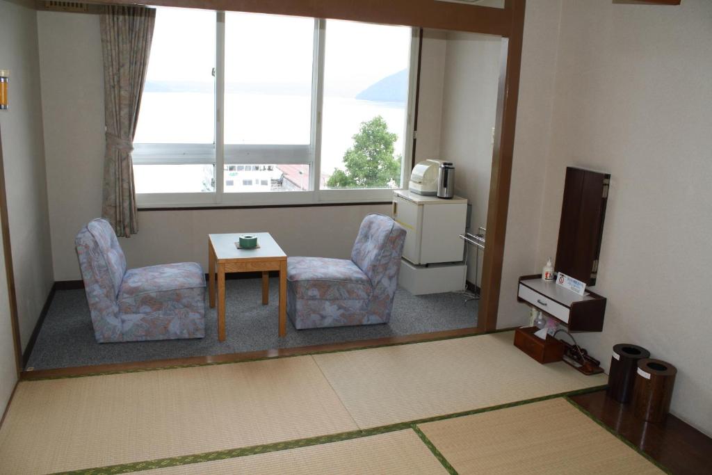 une chambre avec deux chaises, une table et une fenêtre dans l'établissement Hotel Grand Toya, à Lac Tōya 37 autres photos
