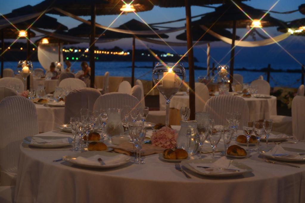 - une table aménagée pour un mariage avec des tables et des chaises blanches dans l'établissement Hotel Salsello, à Bisceglie
