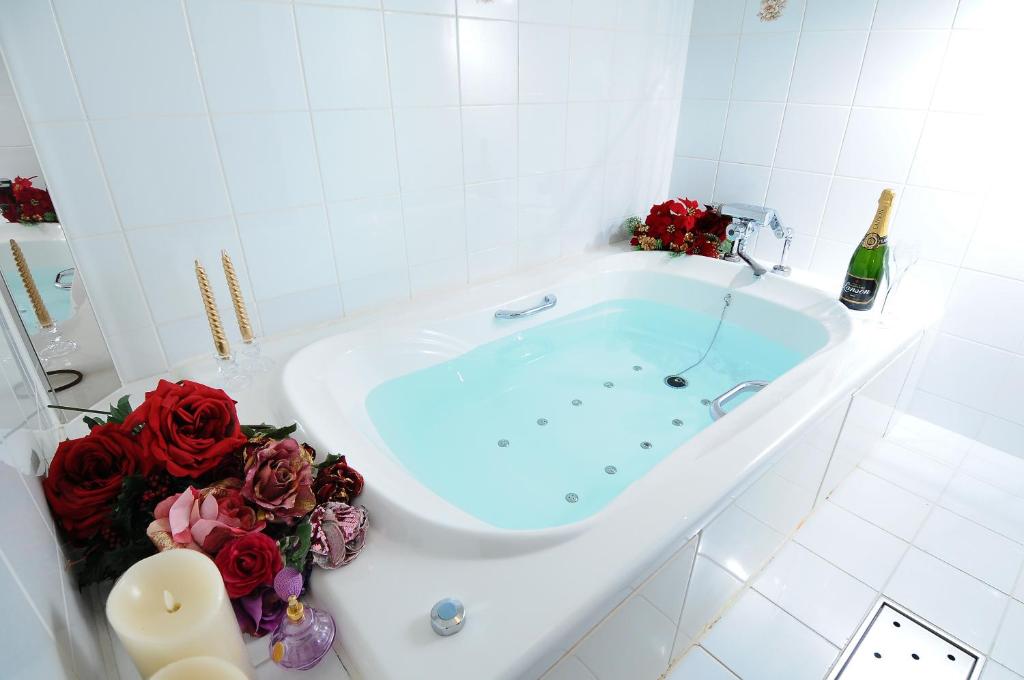 La salle de bains est pourvue d'une baignoire avec des roses rouges. dans l'établissement Hotel Blanc Chapel Christmas Sakai (Adult Only), à Sakai