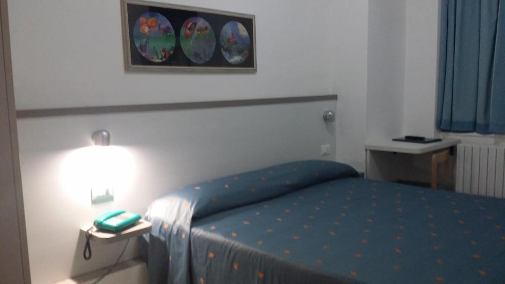 - une chambre avec un lit doté d'un couvre-lit bleu et d'une lampe dans l'établissement Hotel San Giorgio, à Alassio