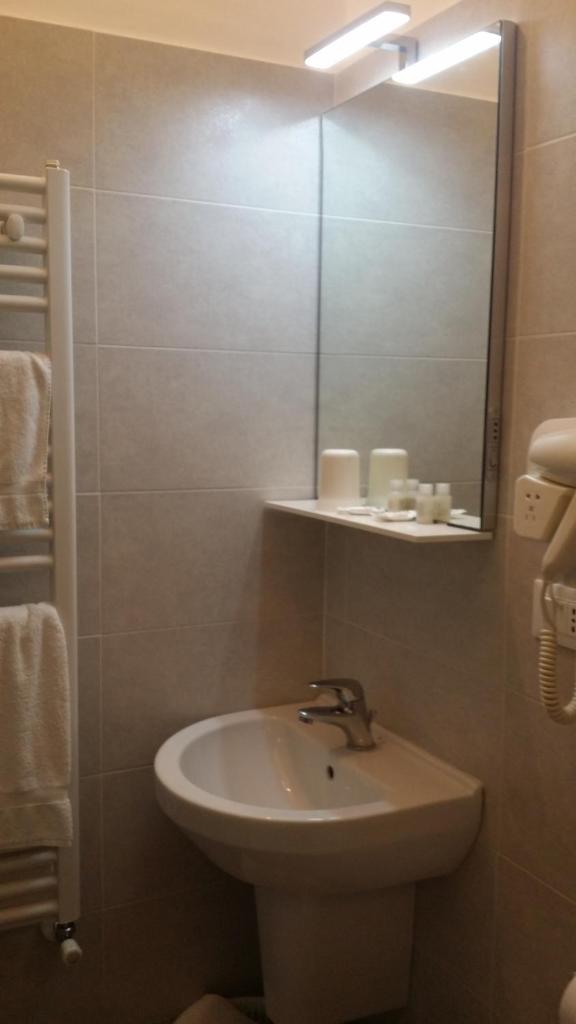 une salle de bain avec un lavabo et un miroir dans l'établissement Hotel San Giorgio, à Alassio