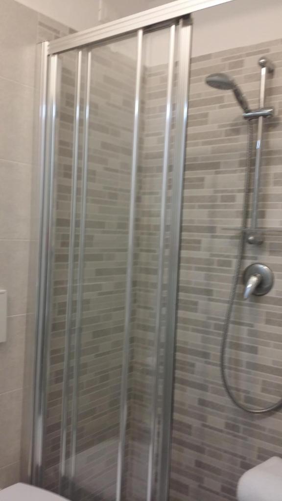 une douche avec une porte vitrée dans une salle de bain dans l'établissement Hotel San Giorgio, à Alassio