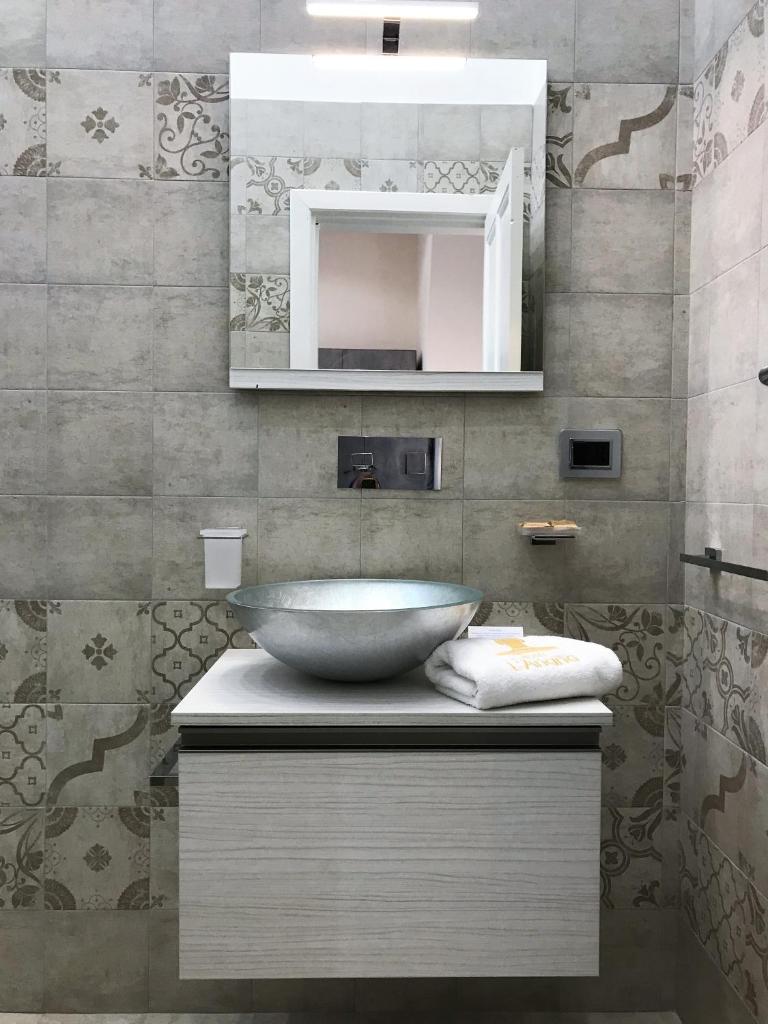 une salle de bain avec un lavabo et un miroir dans l'établissement Hotel L'Ariana ISOLE EOLIE - UNA Esperienze, à Leni