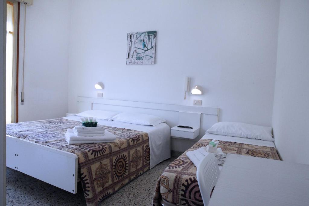 une chambre d'hôtel avec deux lits et une table dans l'établissement Hotel Lagomaggio, à Rimini 17 autres photos