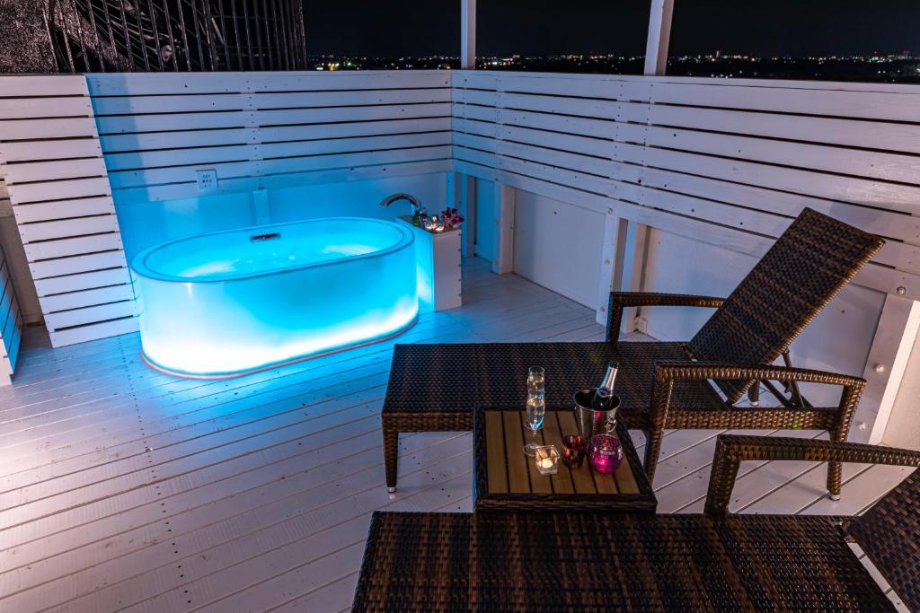une baignoire sur une terrasse avec une table et des chaises dans l'établissement Hotel Aqua Kiss Moriyama (Adult Only), à Moriyama