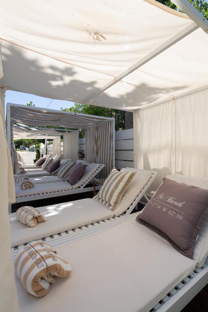 - un groupe de lits assis sous une tente blanche dans l'établissement Best Western Maison B Hotel, à Rimini