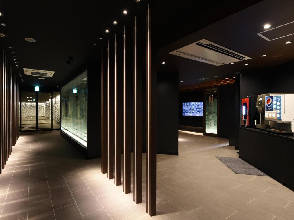 un couloir avec une rangée de colonnes dans un bâtiment dans l'établissement Hotel Crest Chiba Anagawa (Adult Only), à Chiba