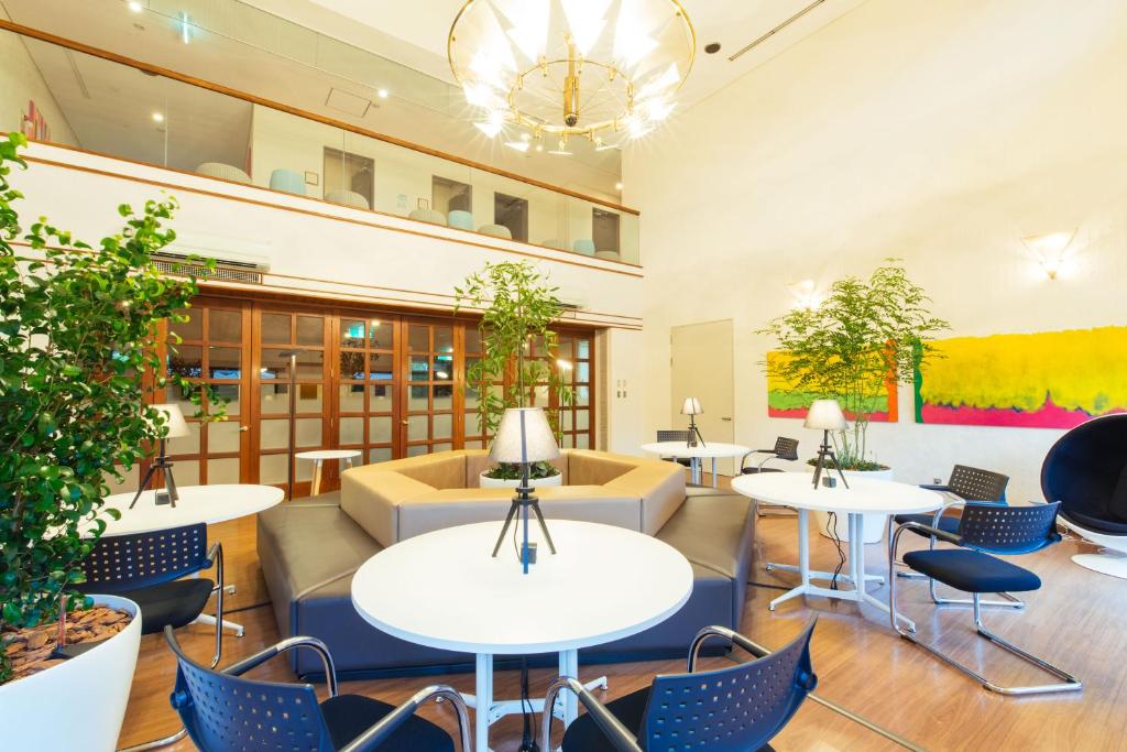 un hall avec des tables et des chaises dans un bâtiment dans l'établissement IKOI Villa, à Karuizawa