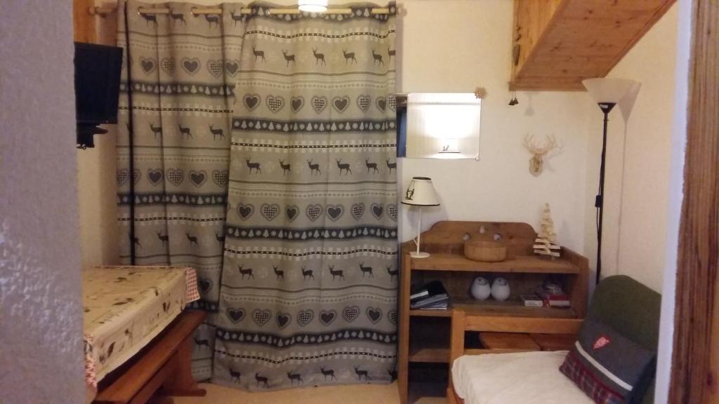 Cette chambre comprend un rideau, un lit et une lampe. dans l'établissement Appartement dernier étage au pied des pistes HIRMENTAZ, à Bellevaux
