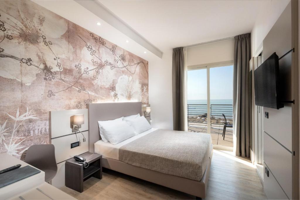 une chambre avec un lit et une vue sur l'océan dans l'établissement Hotel Tritone, à Caorle