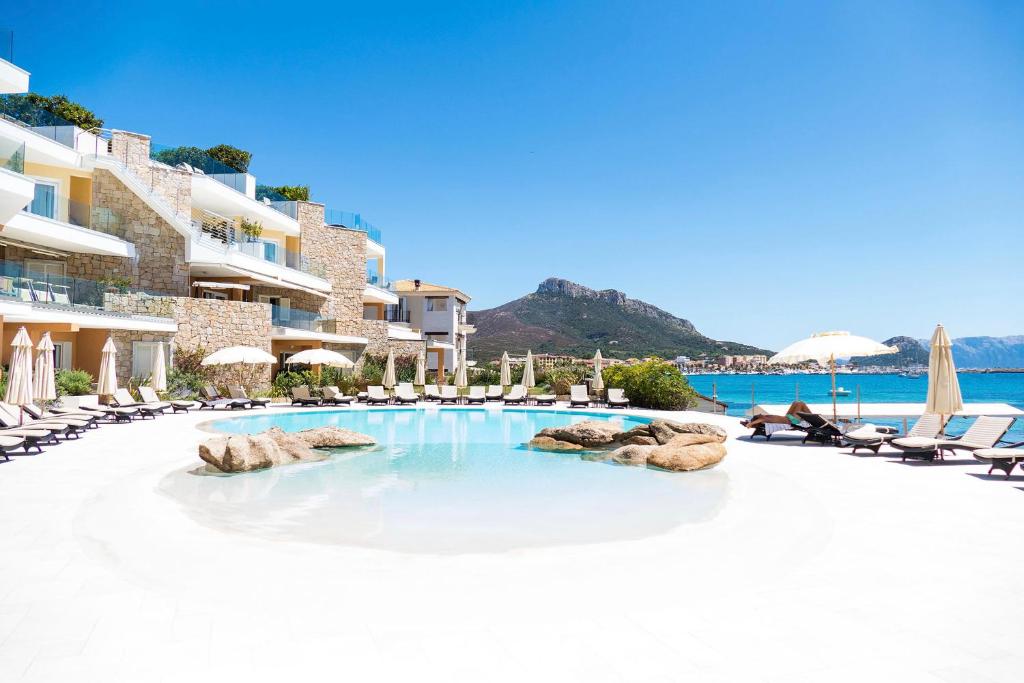 une image d'une piscine dans un complexe hôtelier dans l'établissement Gabbiano Azzurro Hotel & Suites, à Golfo Aranci