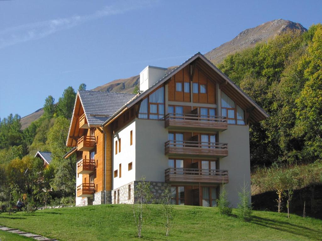 une maison sur une colline avec une montagne dans l'établissement Lagrange Vacances Chalets du Galibier, à Valloire