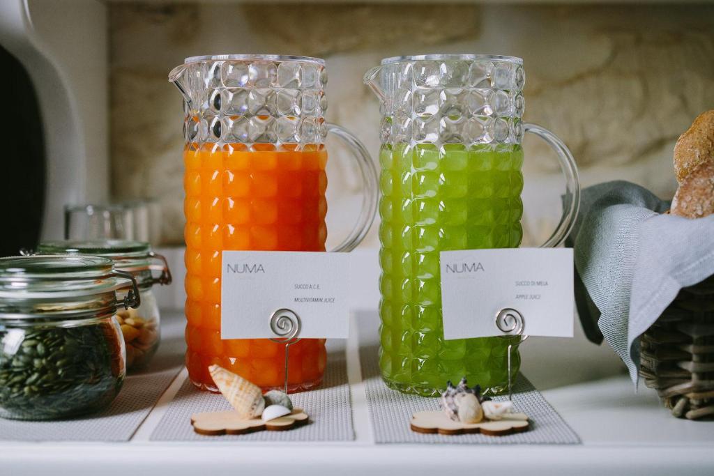 trois vases en verre remplis de liquides de couleurs différentes dans l'établissement NUMA HOTEL, à Numana