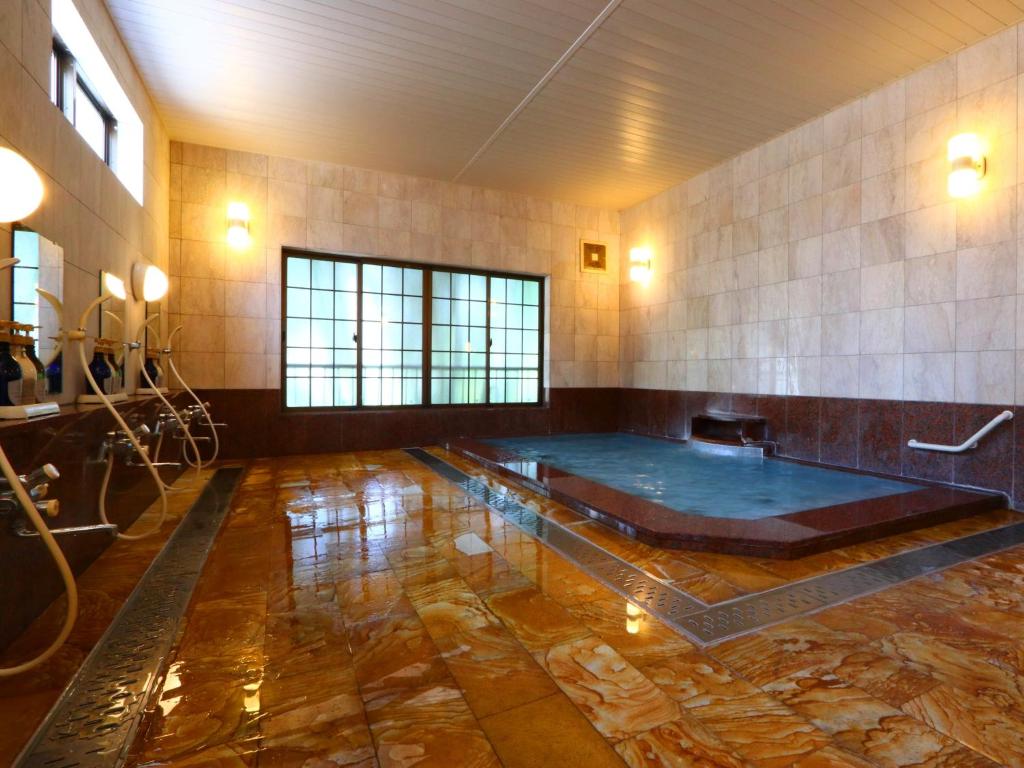 Cette grande chambre dispose d'un bain à remous au milieu. dans l'établissement Takanoya, à Yuzawa