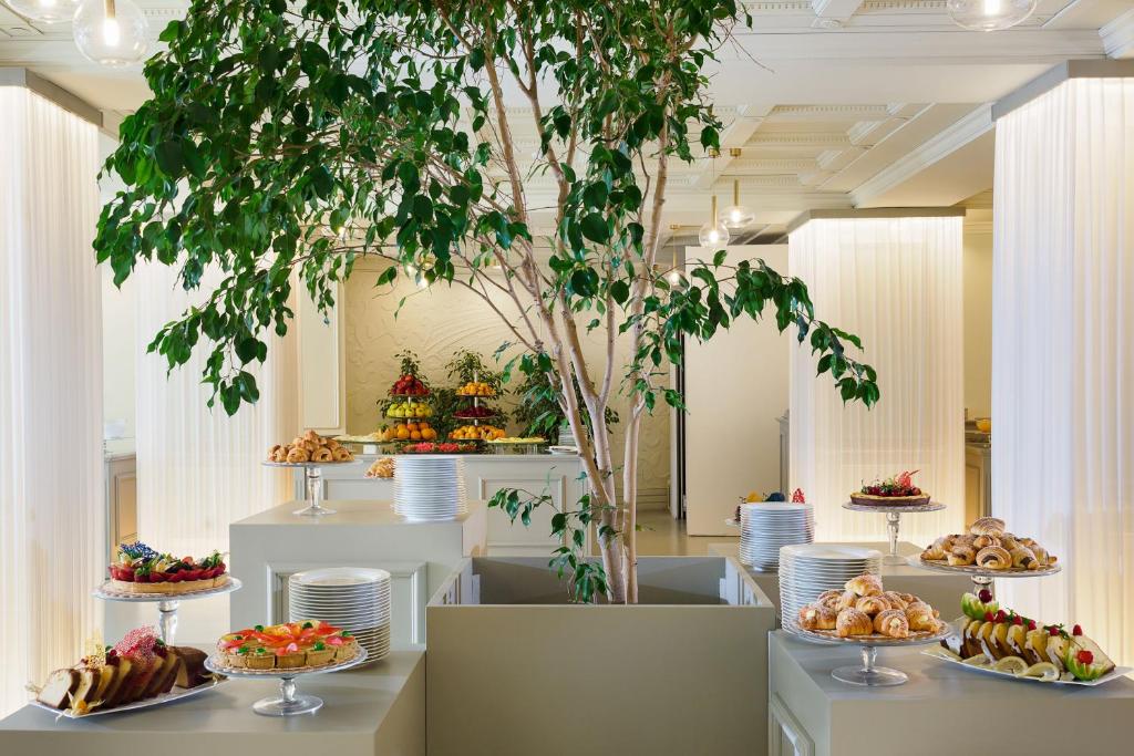 une table remplie d'assiettes de nourriture et un arbre dans l'établissement Atlantis Bay - VRetreats, à Taormine