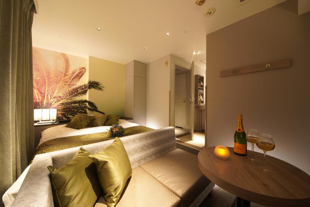 un salon avec deux lits et une table dans l'établissement ルトゥール難波 RetourNANBA 男塾ホテルグループ, à Osaka