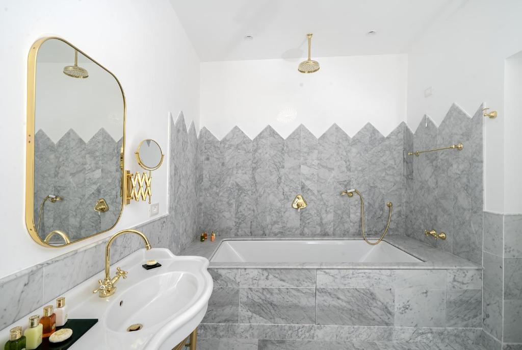 une salle de bain blanche avec une baignoire et un lavabo dans l'établissement Hotel Lorelei Londres, à Sorrente