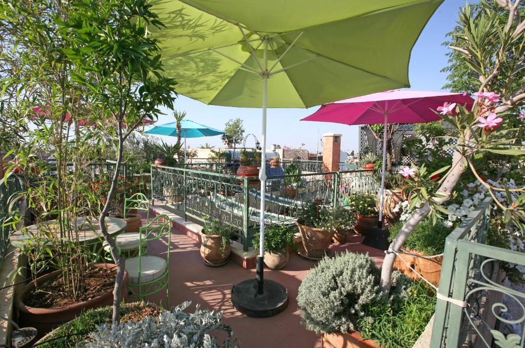 un patio avec un bouquet de plantes en pot et un parasol dans l'établissement Riad Cherihane, à Marrakech