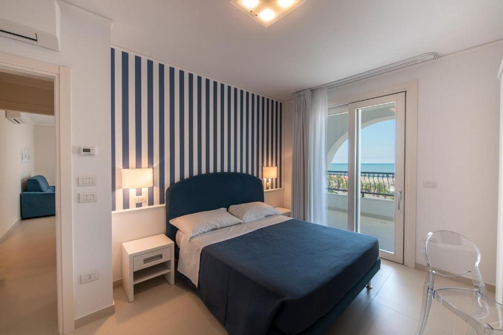 une chambre avec un lit bleu et un balcon dans l'établissement Residence La Villa, à Tortoreto Lido