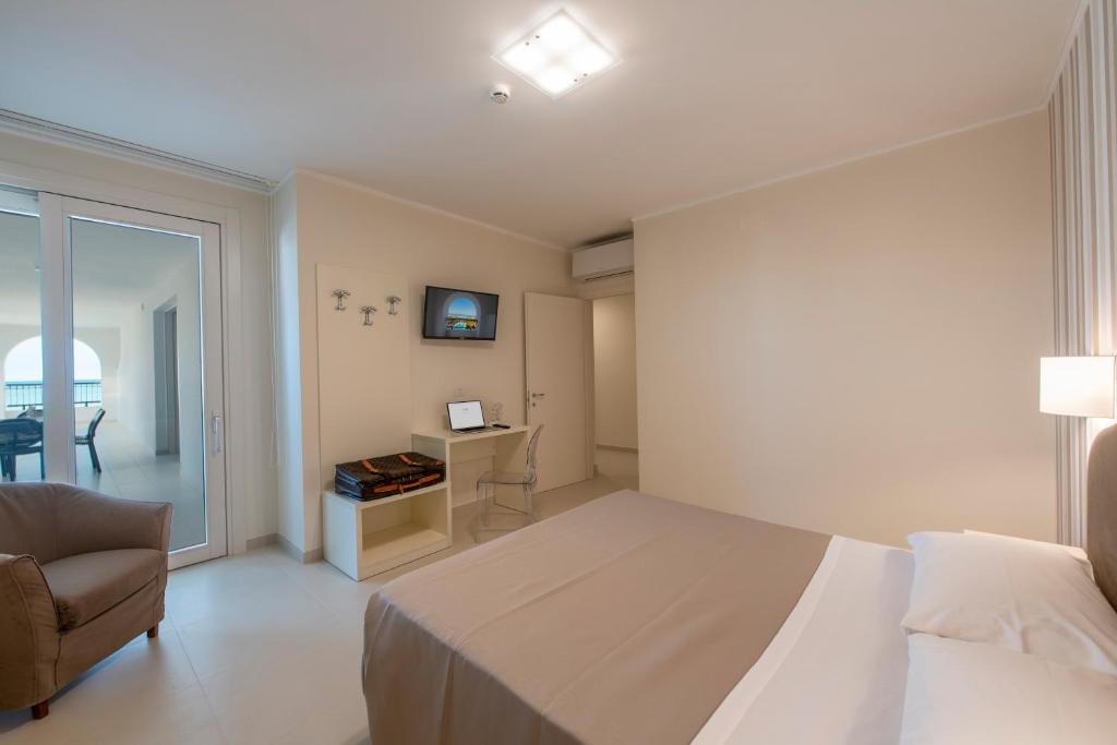 une chambre avec un lit, une chaise et un bureau dans l'établissement Residence La Villa, à Tortoreto Lido