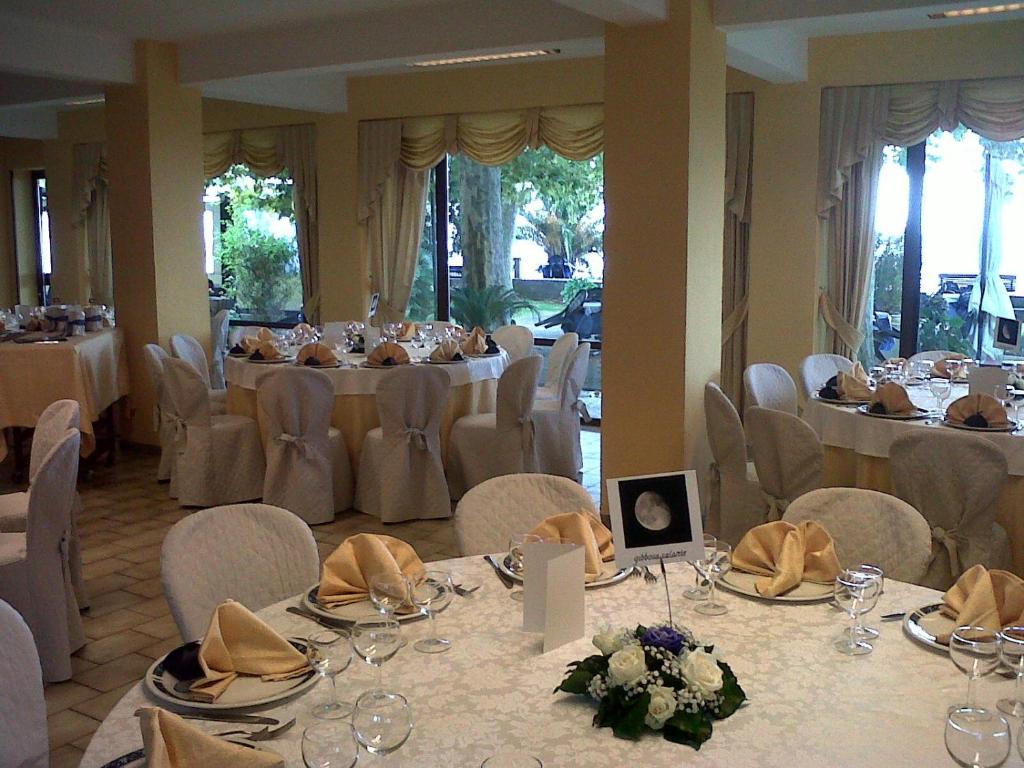 une salle de banquet avec des tables, des chaises et un chercheur de table dans l'établissement Hotel Eden Sul Lago, à Bolsena 135 autres photos