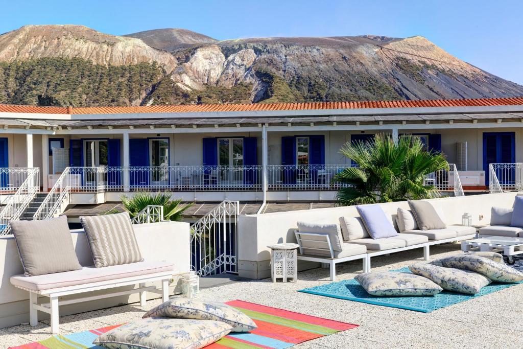 - un ensemble de chaises et d'oreillers sur la terrasse dans l'établissement Les Sables Noirs & Spa, à Vulcano