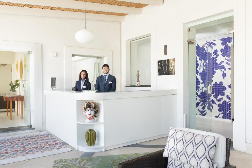 2 personnes debout à un comptoir dans une pièce dans l'établissement Les Sables Noirs & Spa, à Vulcano 71 autres photos