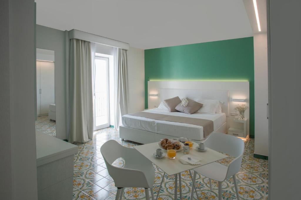 une chambre d'hôtel avec un lit, une table et des chaises dans l'établissement Lloyd's Baia Hotel, à Vietri 112 autres photos