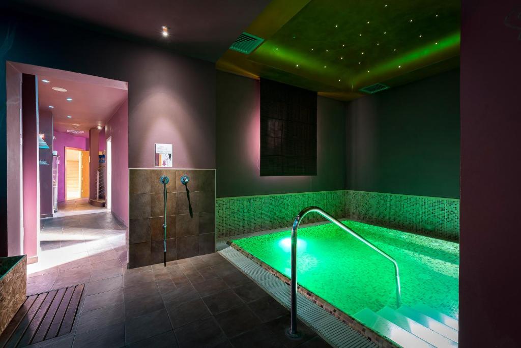 une grande salle de bain avec une baignoire à l'eau verte dans l'établissement Sovrana Hotel & SPA, à Rimini