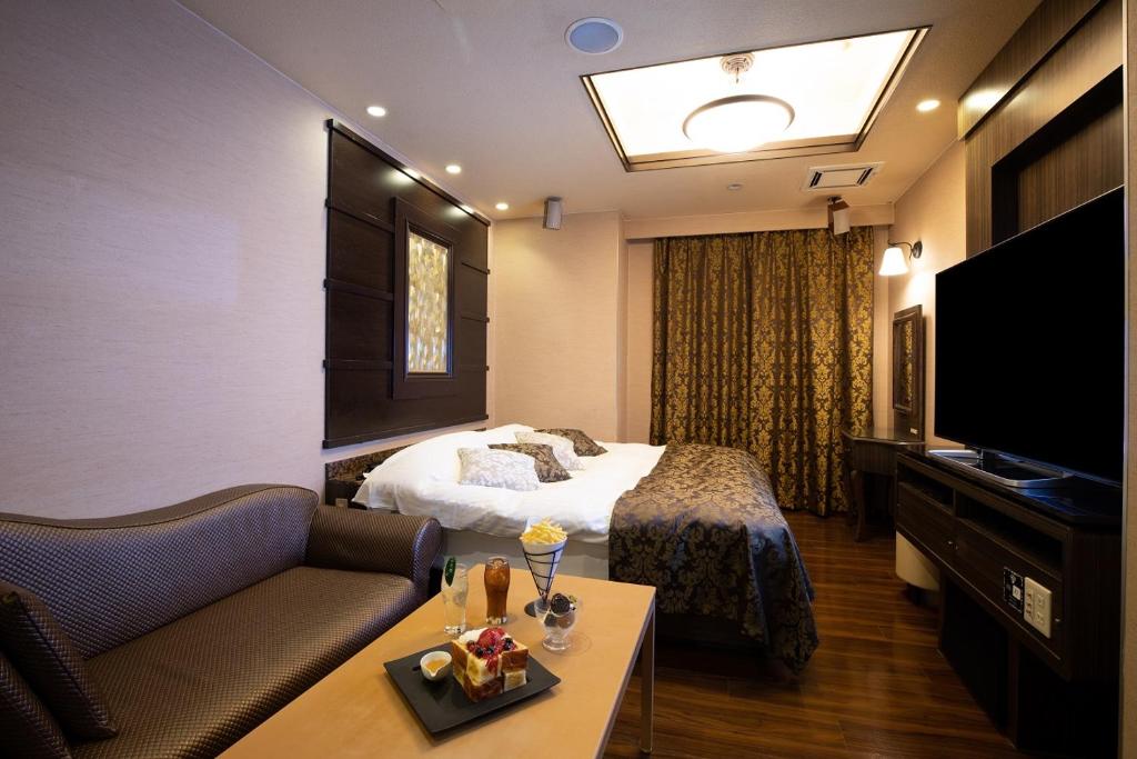 une chambre d'hôtel avec un lit et une télévision dans l'établissement ホテル マイン 岐阜, à Ginan