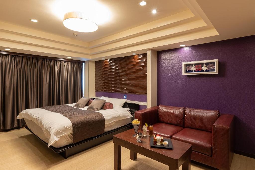 une chambre avec un lit et un canapé dans l'établissement ホテル アン 岐阜-大人専用, à Gifu