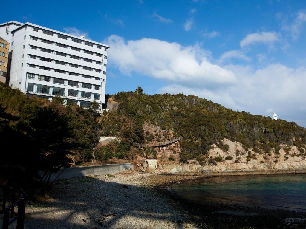 un bâtiment situé sur une colline à côté d'une masse d'eau dans l'établissement Naruto Kaigetsu, à Naruto
