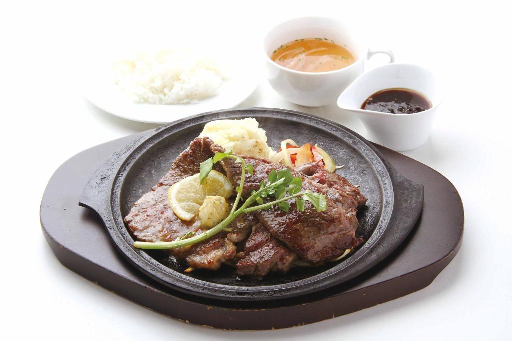 une assiette de nourriture avec de la viande et des légumes sur une table dans l'établissement Hotel Aqua Kiss Moriyama (Adult Only), à Moriyama