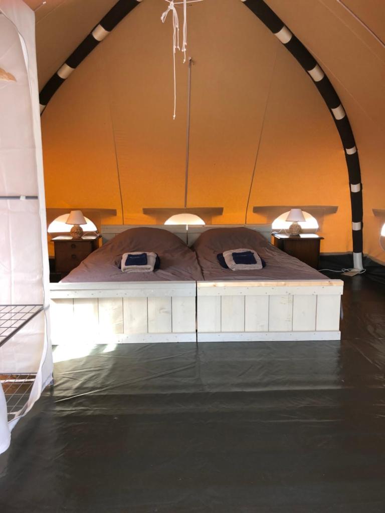 - un lit au milieu d'une chambre avec eau dans l'établissement Glamping Resort Bousset, à Chiddes