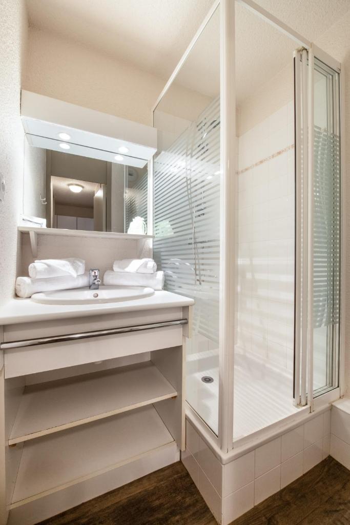 une salle de bain blanche avec une douche et un lavabo dans l'établissement Neige et Soleil, à Montchavin