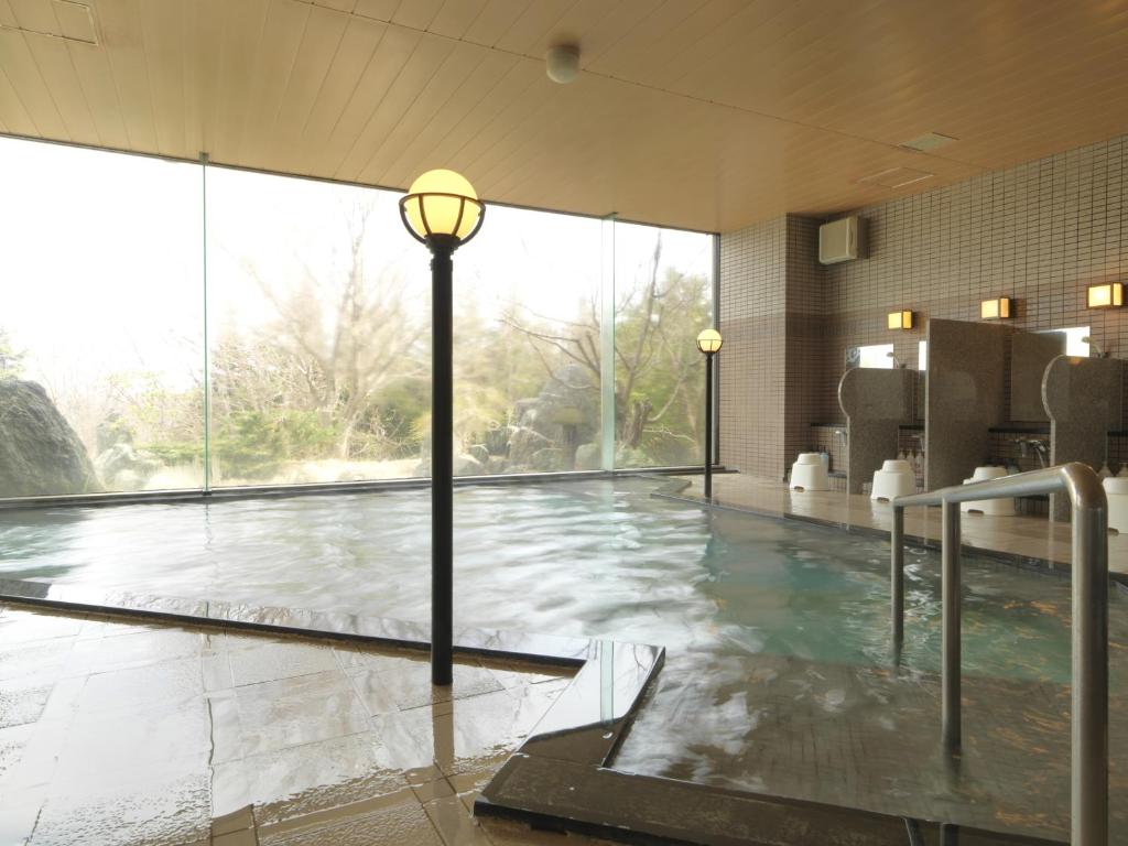 une piscine éclairée au milieu d'un bâtiment dans l'établissement Hokuten no Oka Abashiriko Tsuruga Resort, à Abashiri