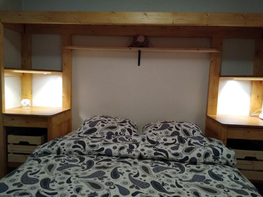 Ce lit se trouve dans un dortoir doté de 2 tables de nuit et de 2 fenêtres. dans l'établissement Chalets D'Or, Les Deux Alpes, à Mont-de-Lans